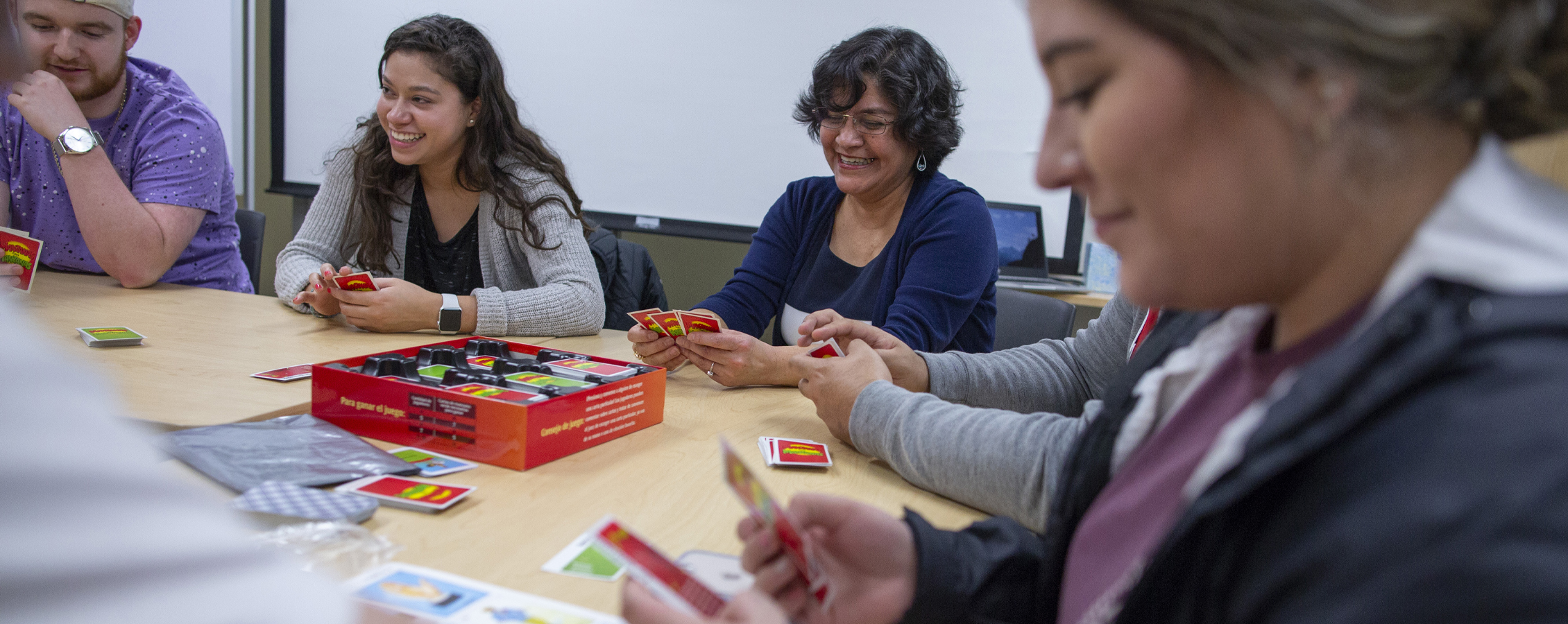 Estudiantes y un profesor jugando un juego de lotería en un club español.