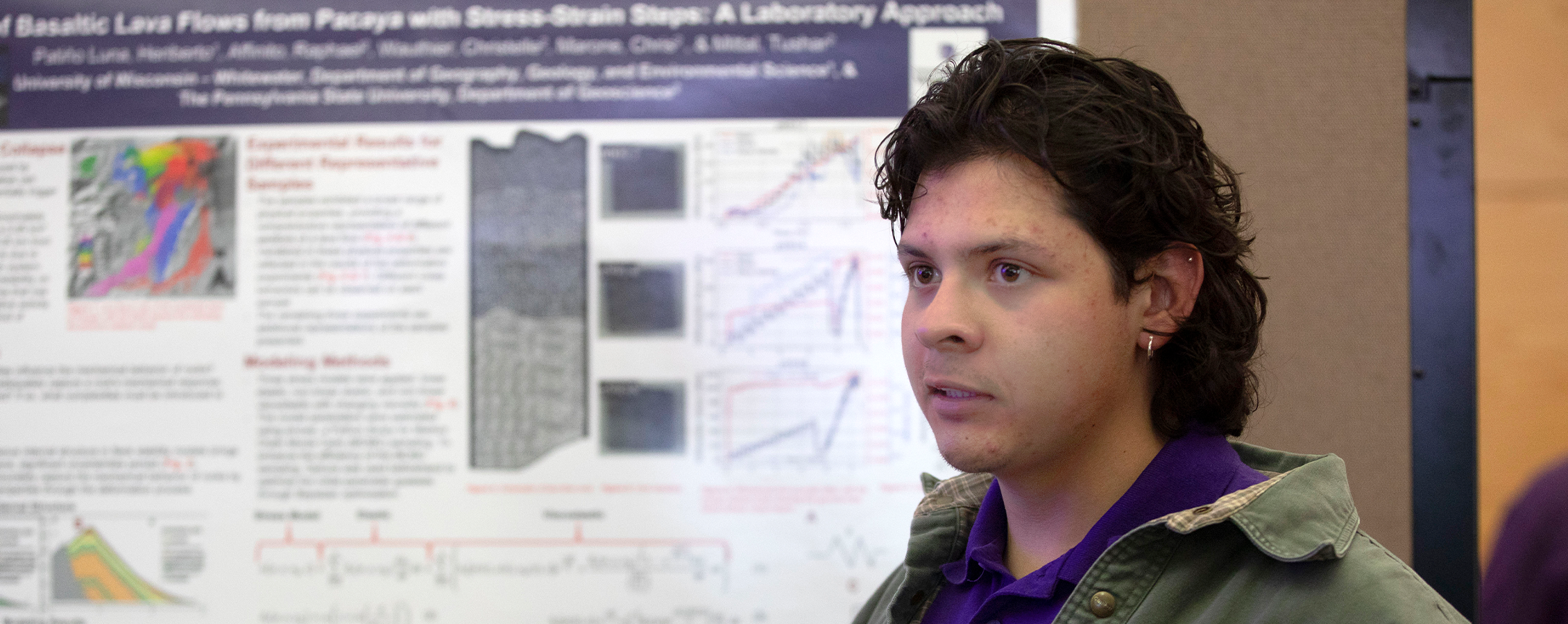 Un estudiante universitario mostrando su investigación en un simposio.