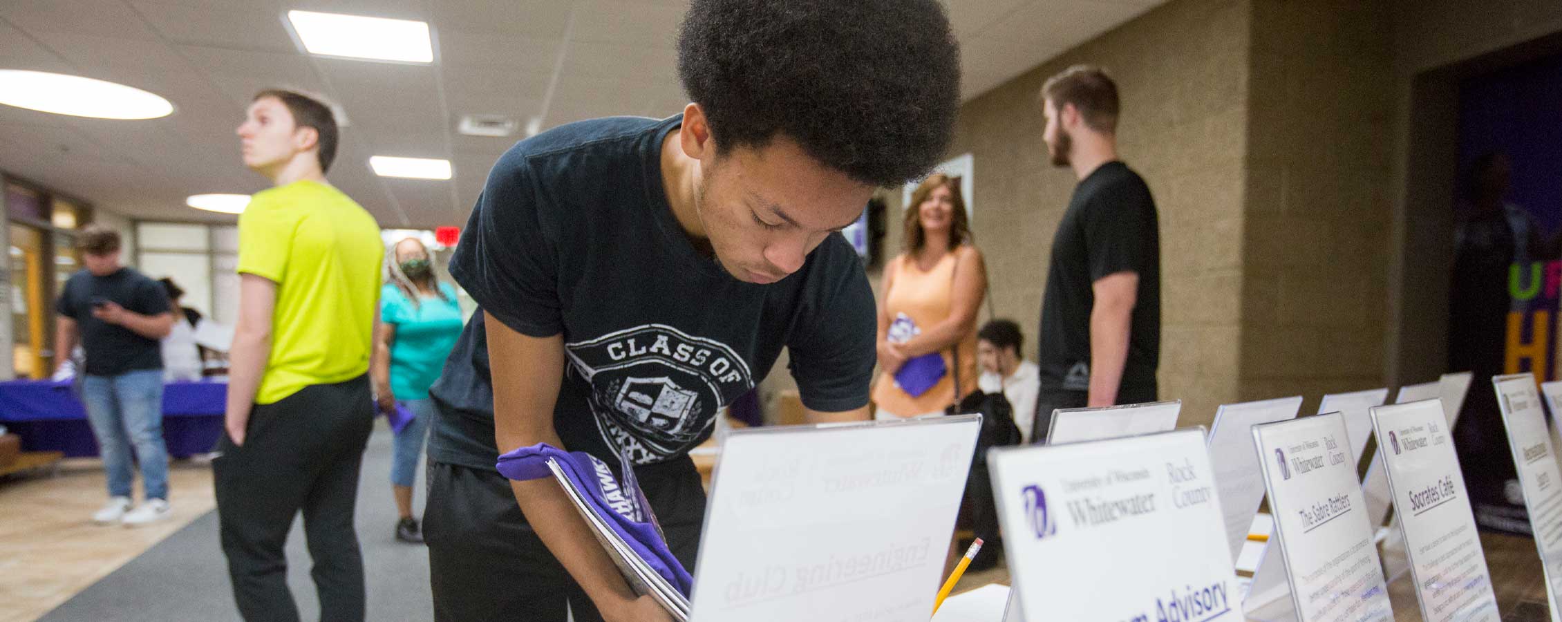 Man signs a sheet at a table