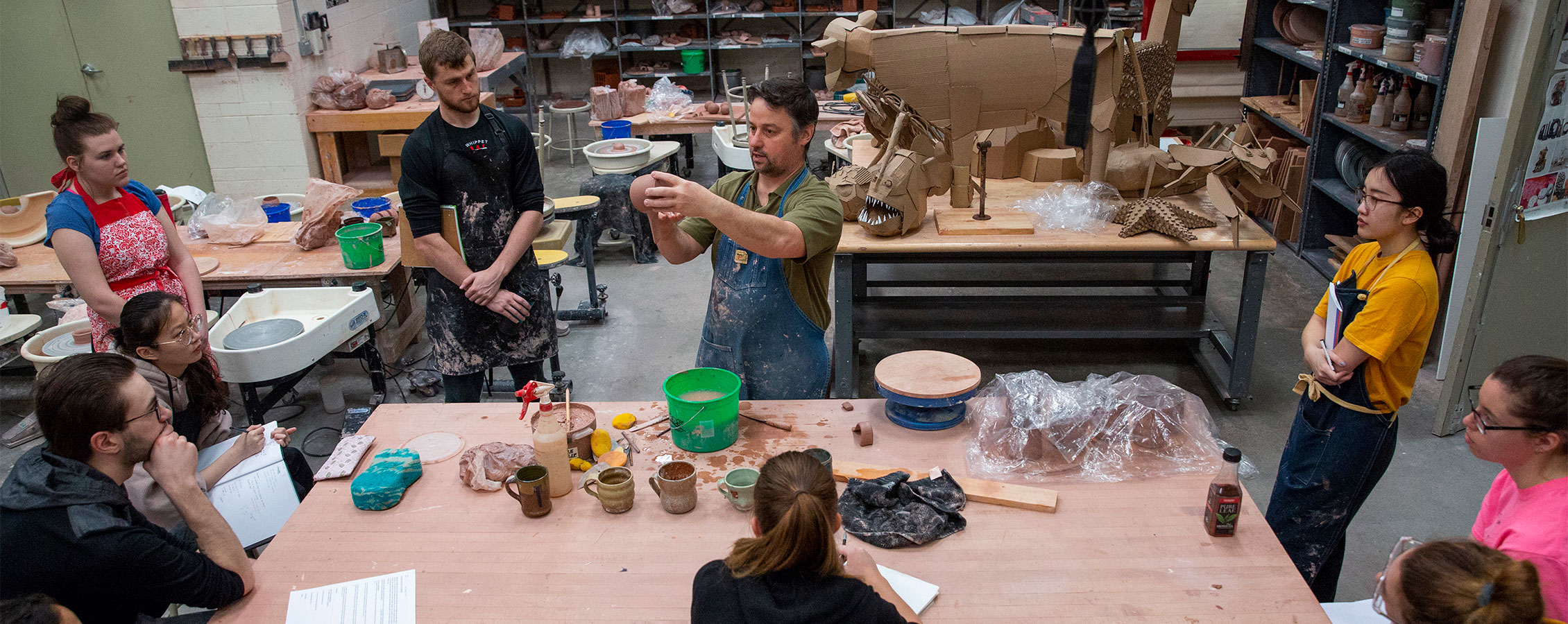 Art and design student learns about sculpting with a professor at the University of Wisconsin Whitewater.