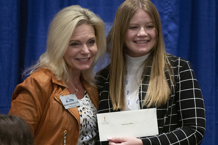 McClane Noffke stands with the president and CEO of the Wisconsin Broadcasters Association and holds her award.