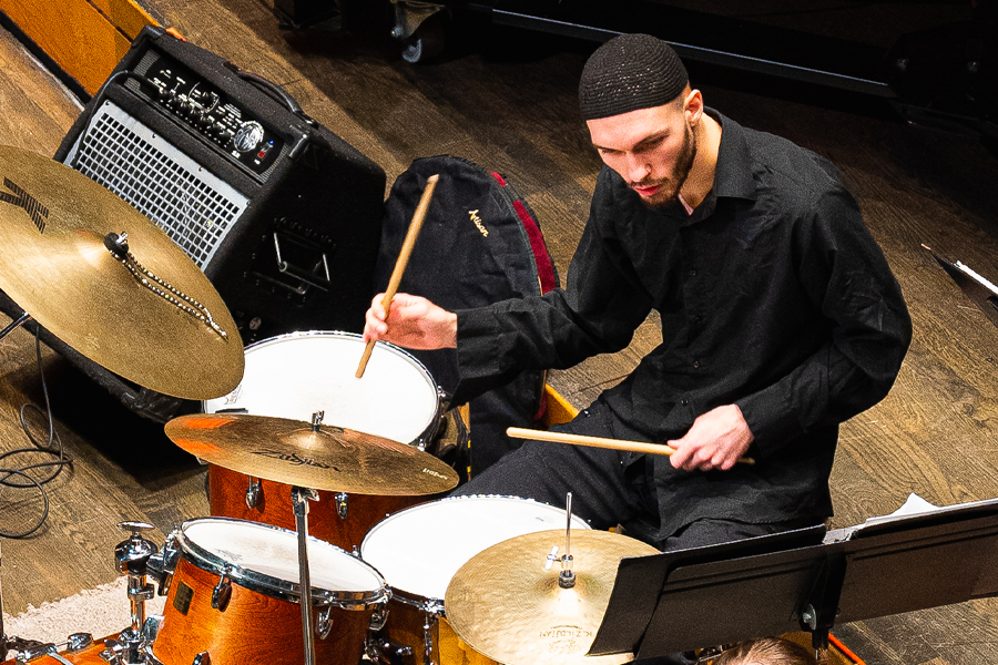 A member of the jazz band plays snare drums and cymbals.