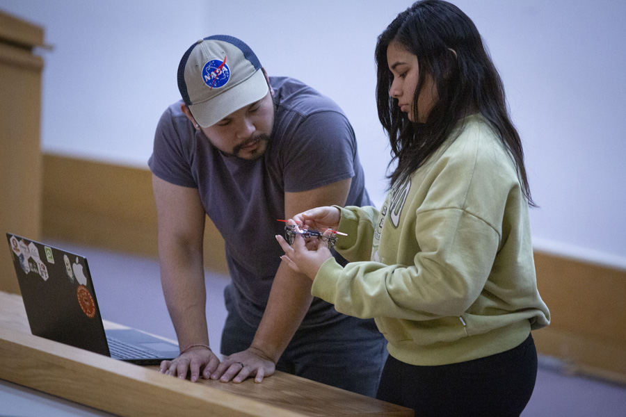 Two students looking at drone.