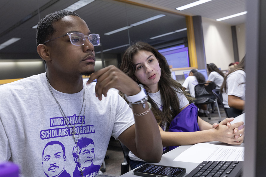 Two students looking at computer together.