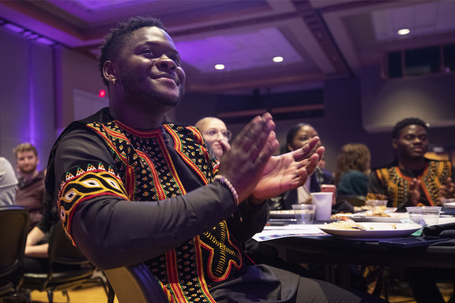 A student claps along to the music at the International Dinner.