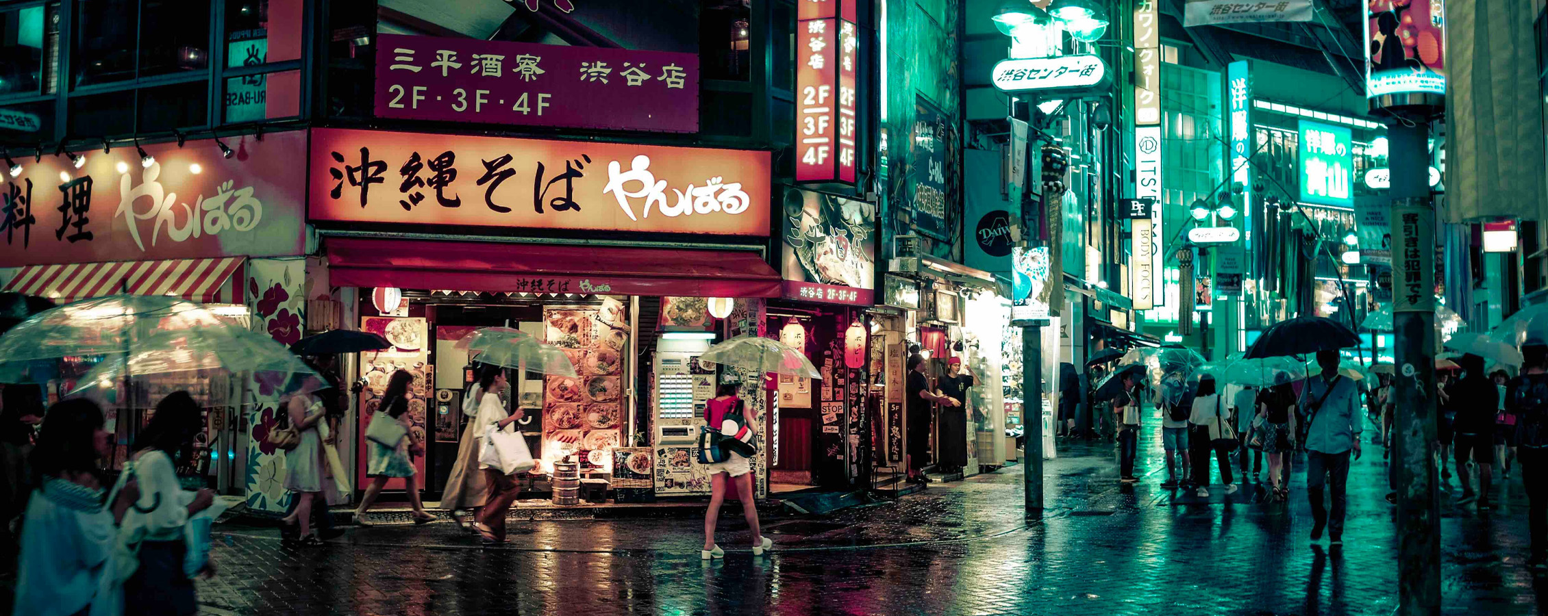 Street lights glow in a busy, urban city in Japan at night.