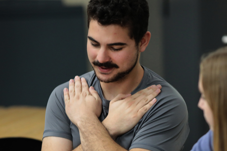 A student makes the sign for love in sign language.