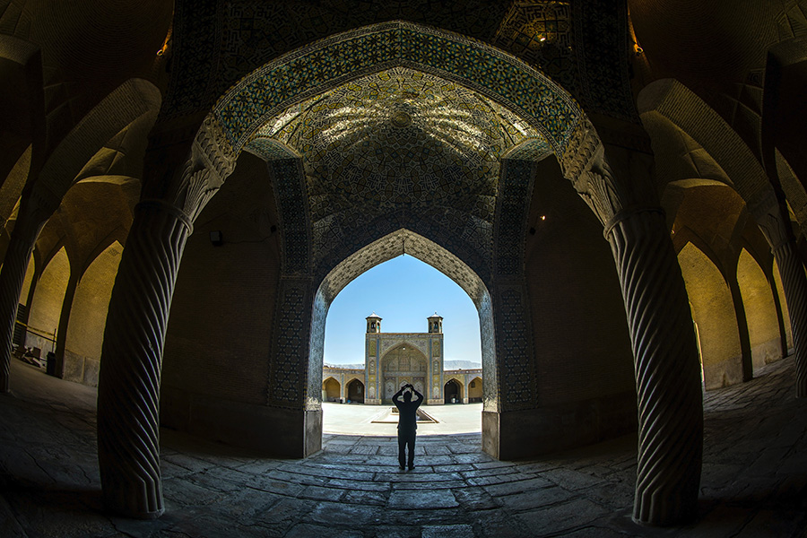 A person stands among buildings in Iran.