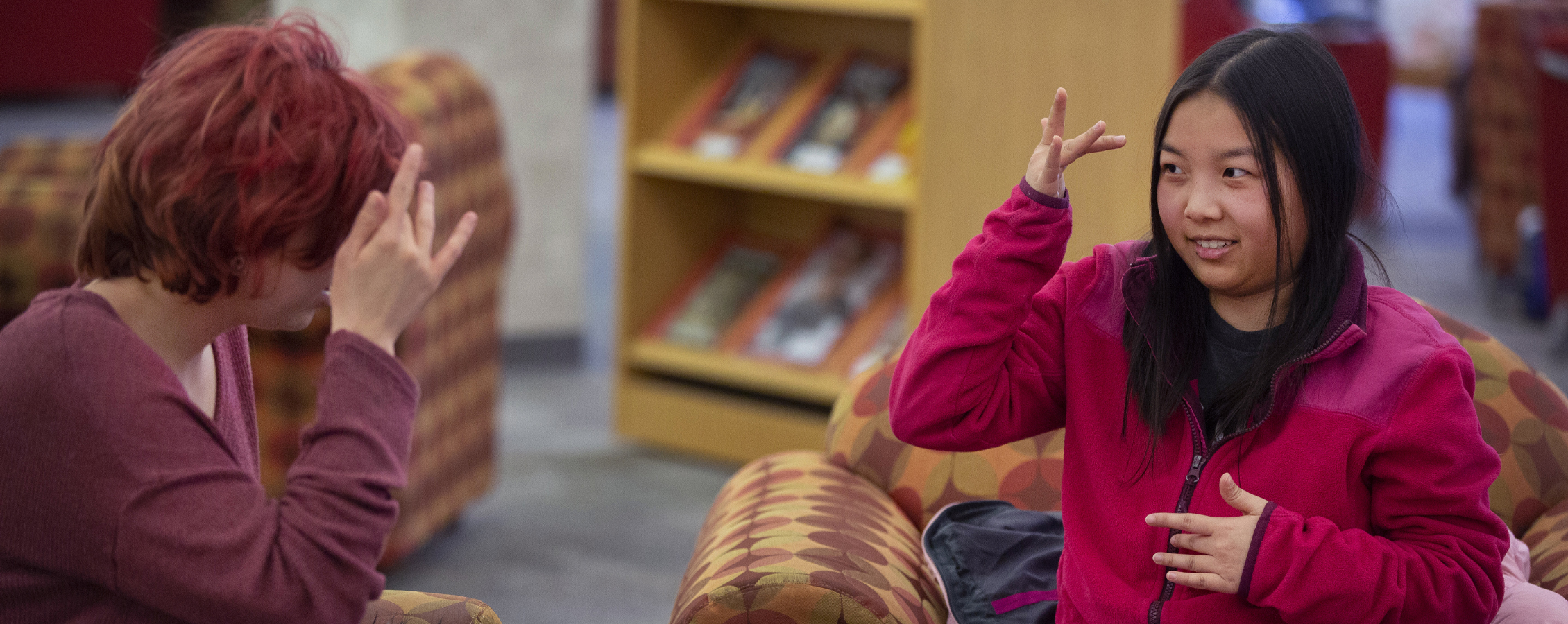 A person tutors another person in sign language.