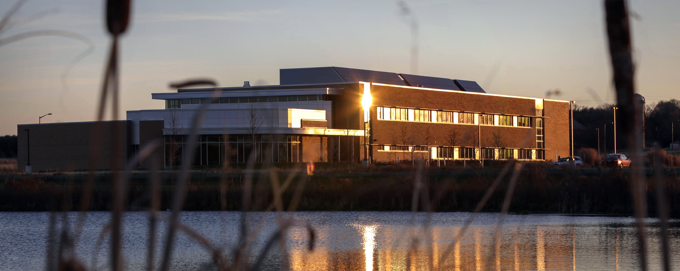 An exterior photo of the Wisconsin Innovation Service Center across from a small body of water.