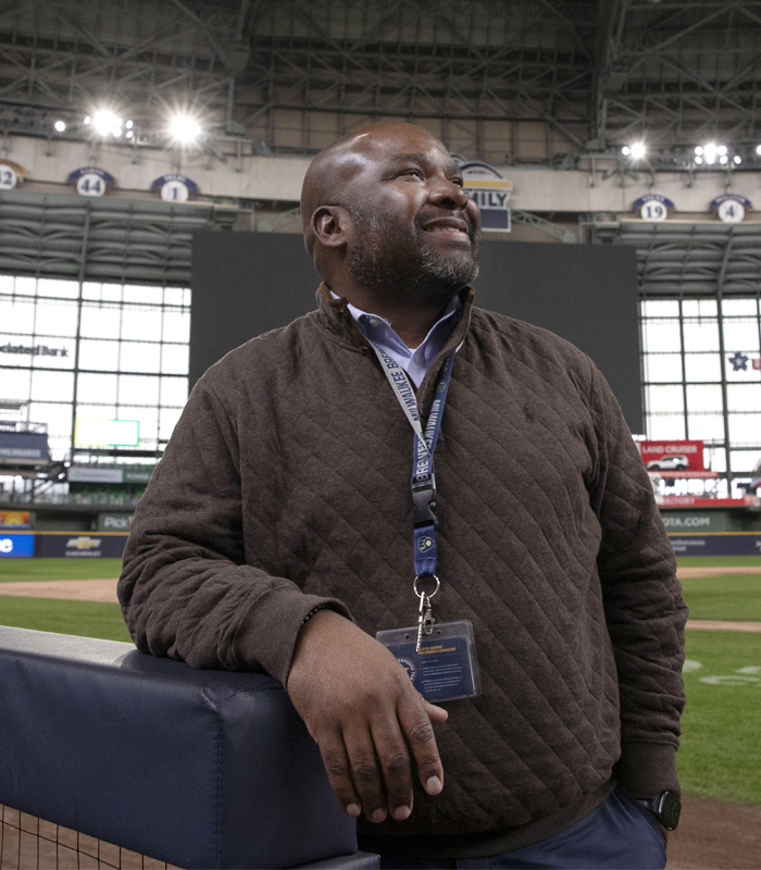 A person stands in a stadium with a smile on their face.
