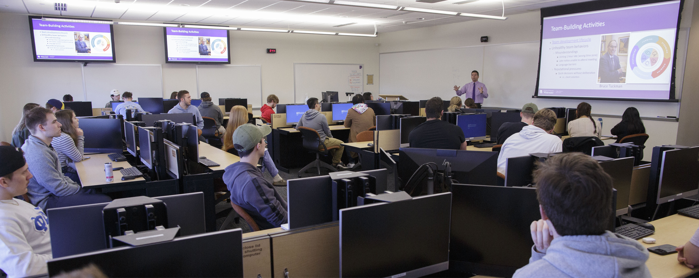 A faculty member speaks at the front of class.