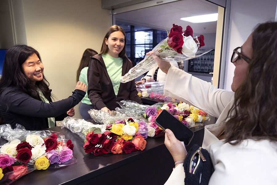 Students sell flowers behind a counter.