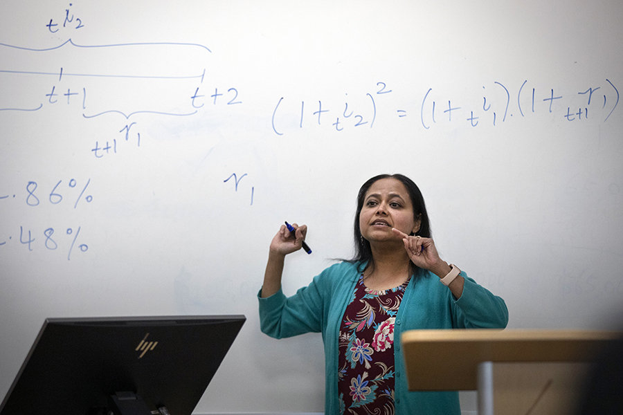 A faculty member teaches at the white board.