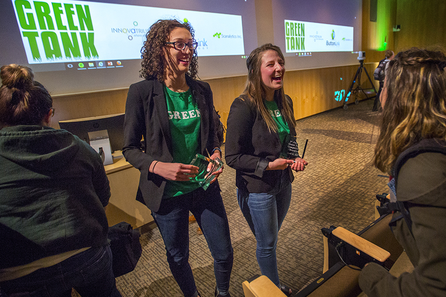 Two students standing together wear green T-shirts that say Green Tank.