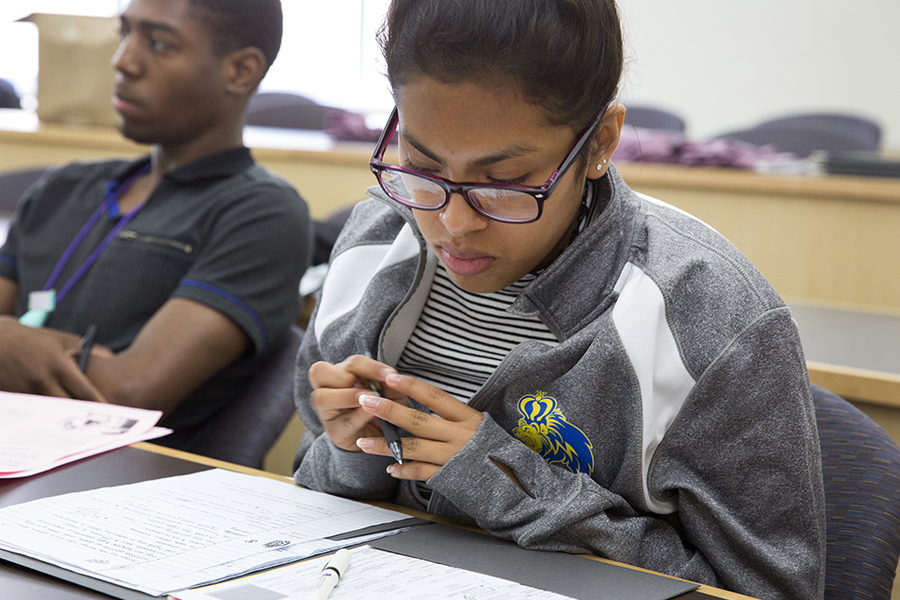 A student in a classroom looks down at her notes.