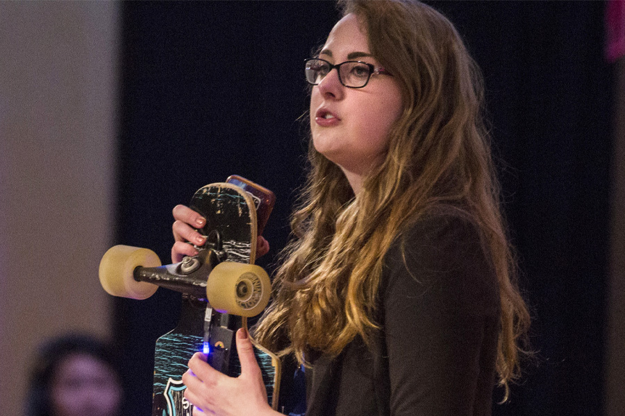 A student holds an enhanced skateboard.