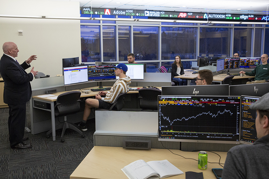 Students sit in desks around the room in a finance class.