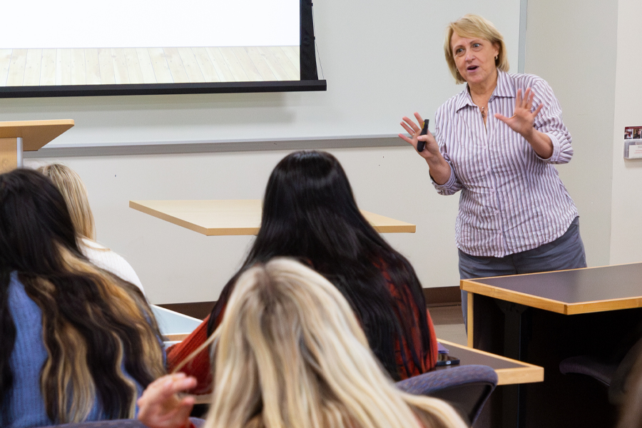 A faculty member speaks at the front of class.