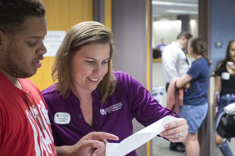 Beth John looks at a piece of paper with a student.