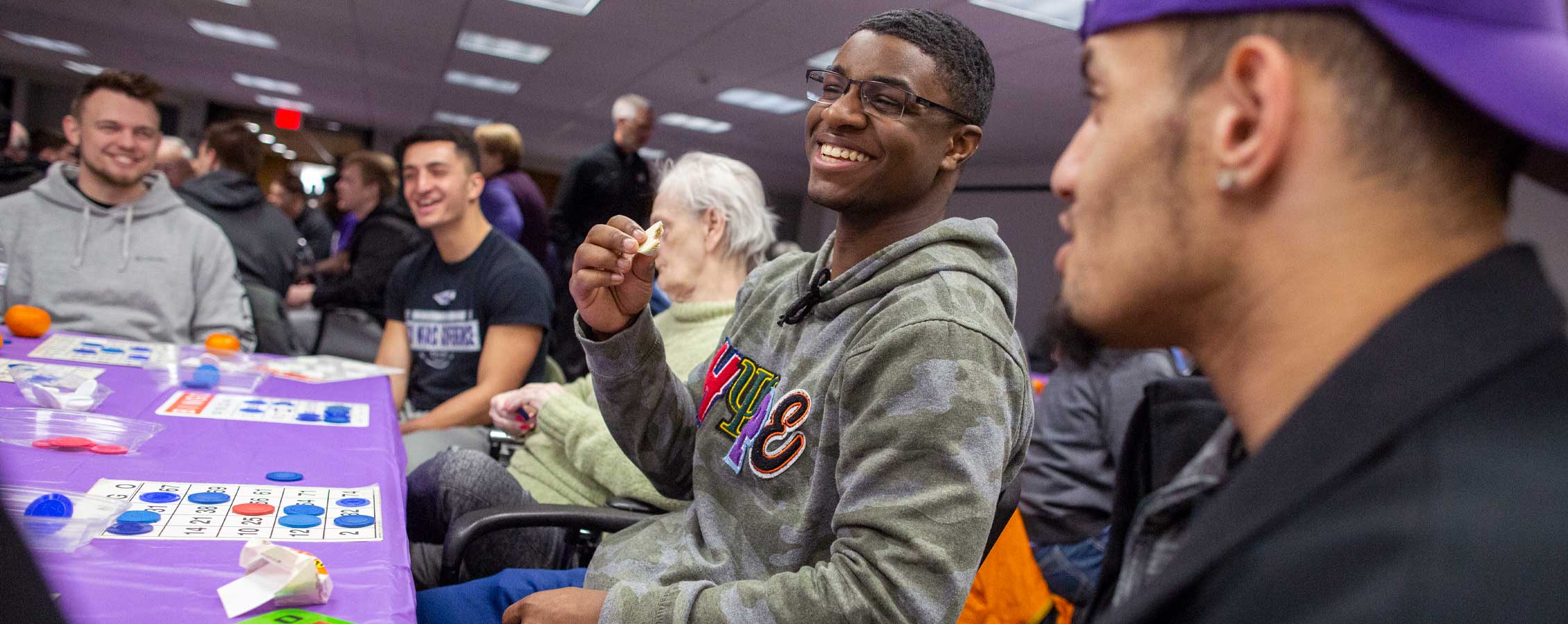 Students laugh together at a bingo table