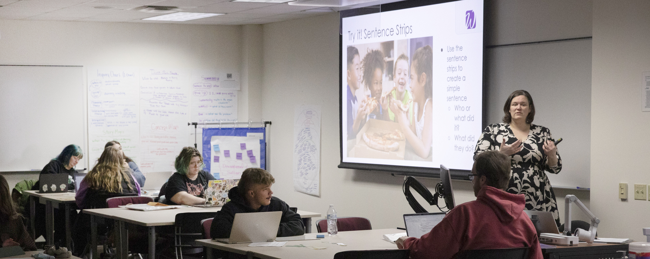 A person teaches in front of a class.