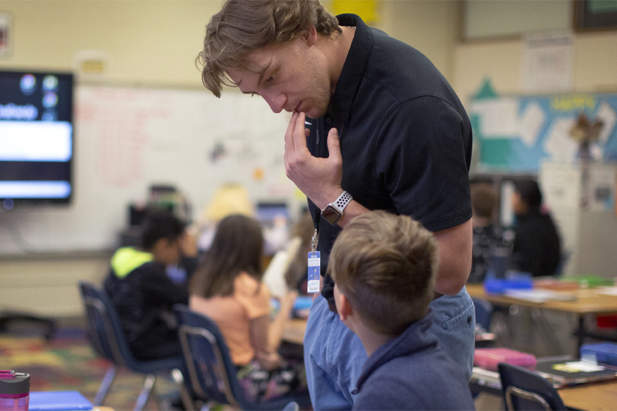 A UW-Whitewater student teacher works with a student.