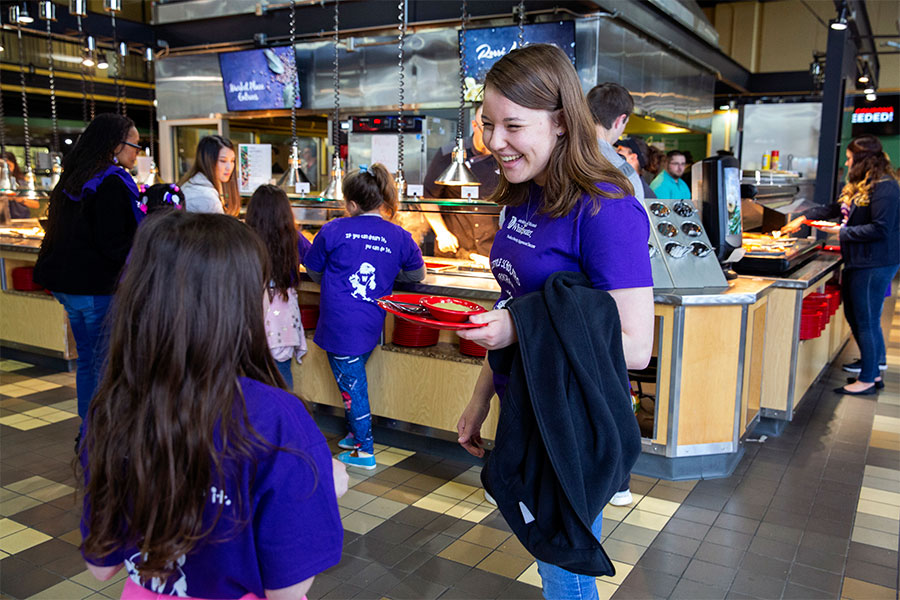 A faculty member teaches at the front of a special education class.