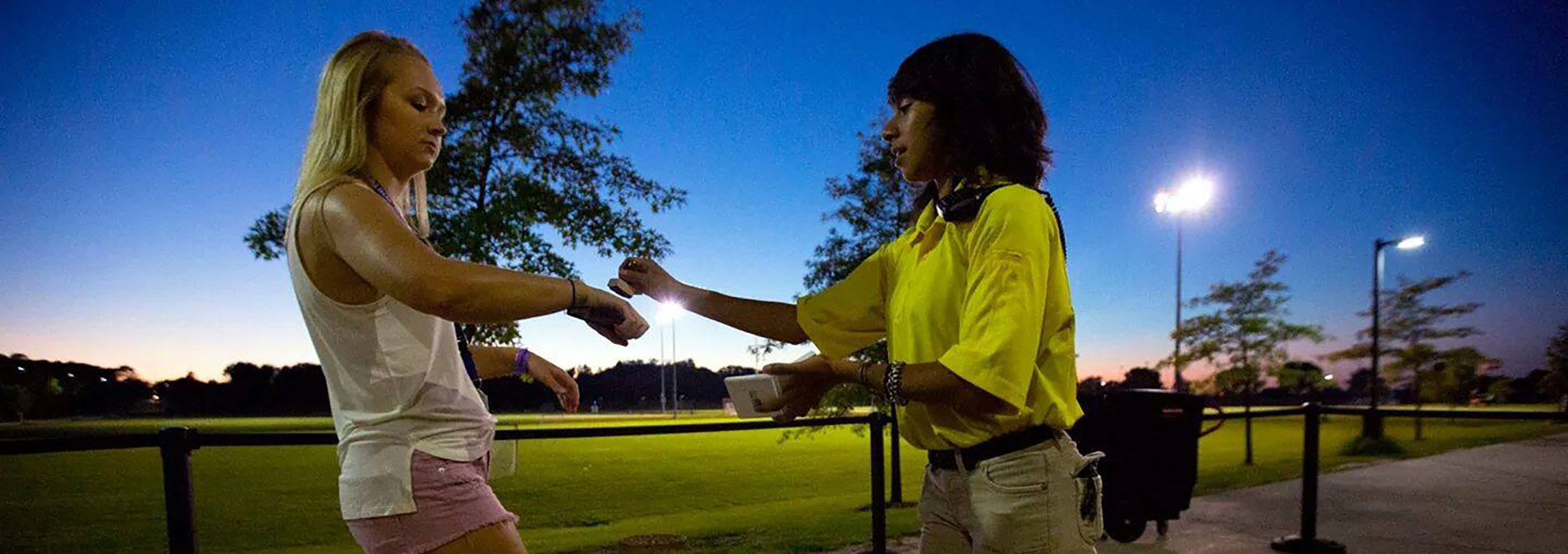 Woman stamping another woman's hand at a university event