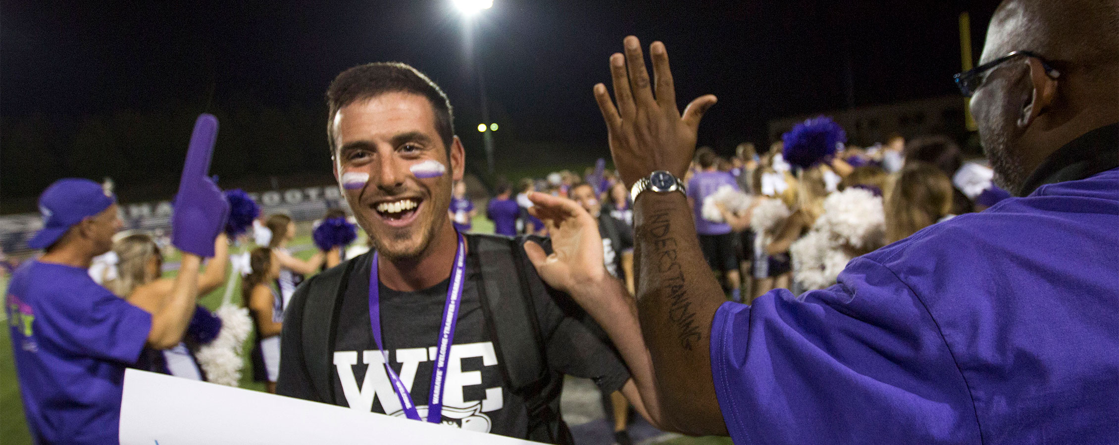 A transfer student runs through a human tunnel at a welcome rally on the UW-Whitewater campus.