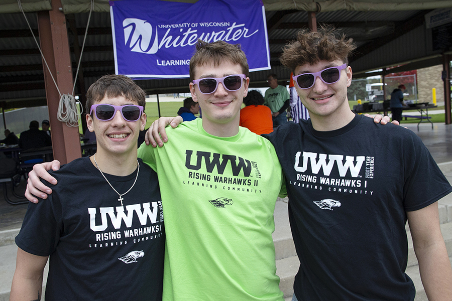 Three students with their arms around each other's shoulders wearing shirts that say UWW.