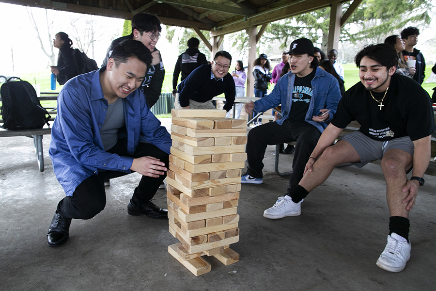 Students from Latinos Unidos gather around to play giant Jenga.