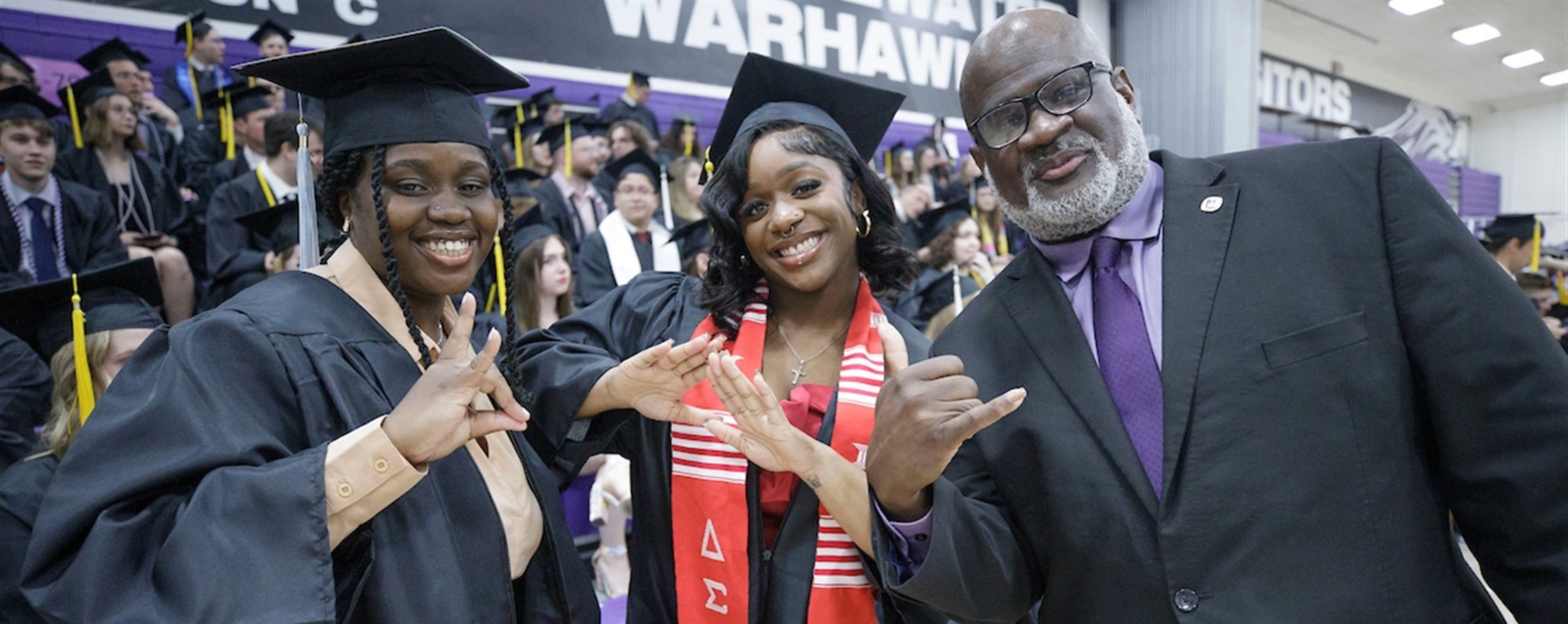 Chancellor King poses with two adult graduates