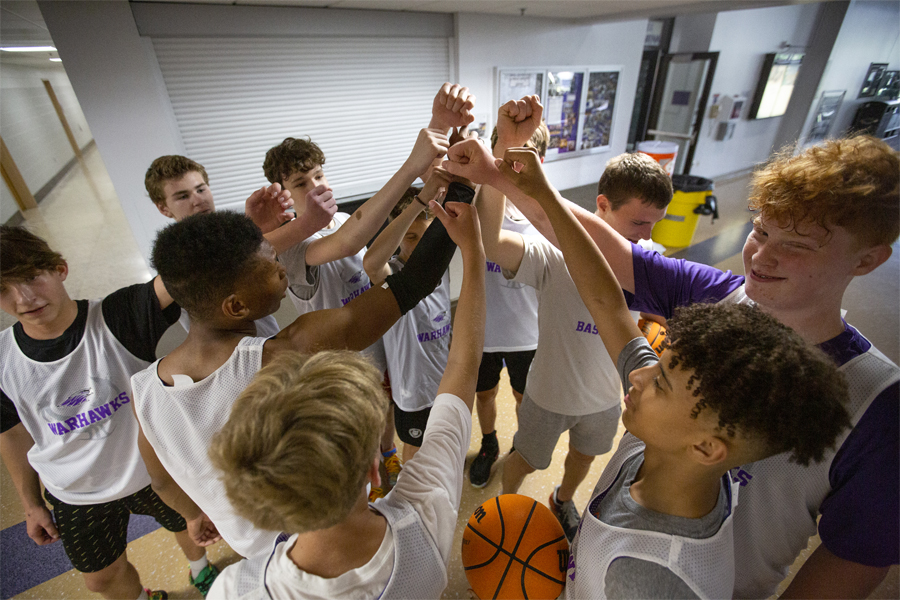 Boys basketball campers put their hands together.