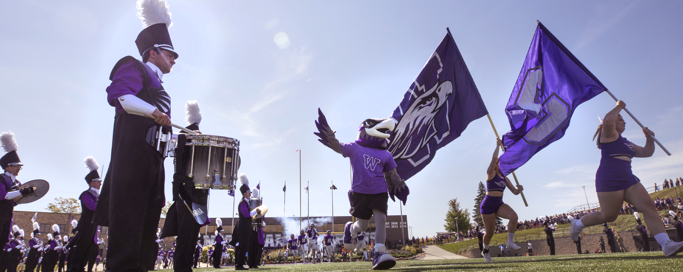 Willie Warhawk runs onto the Perkins Stadium field with the band.