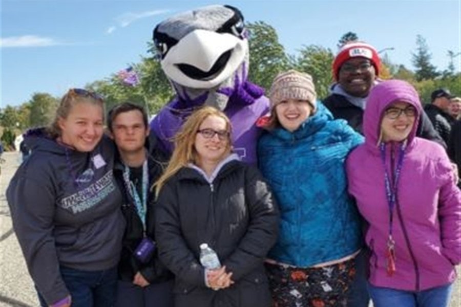 LIFE students pose with Willie the Warhawk at a football game.