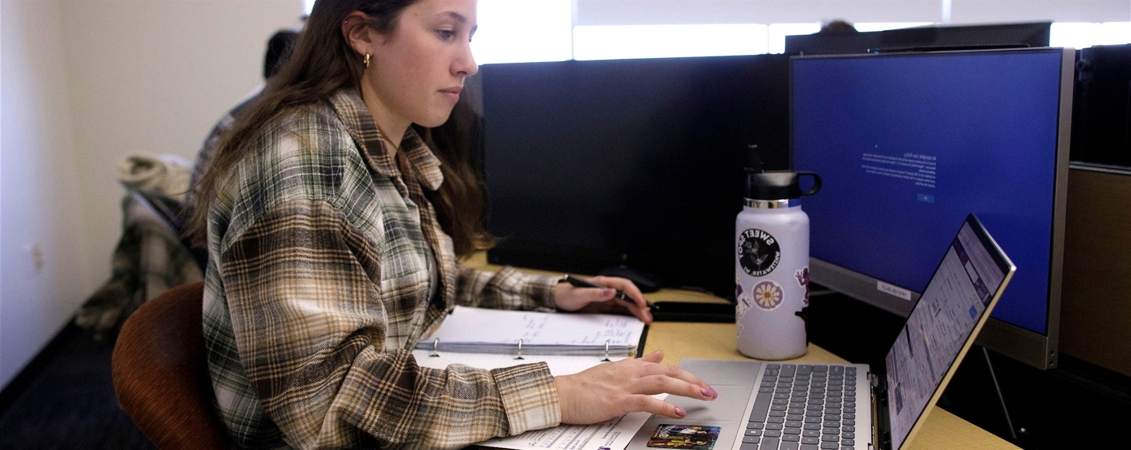 Student working on a computer in Hyland Hall