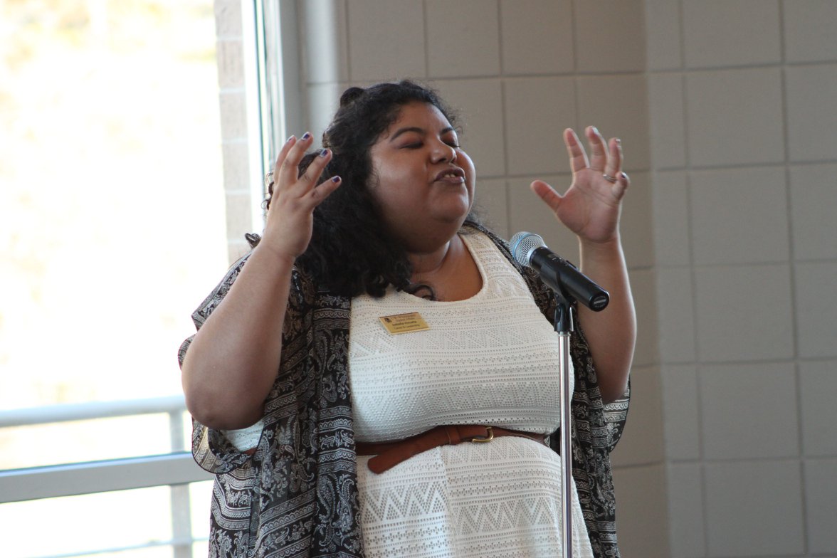 Pride Graduate Assistant performing a monologue at the Rainbow Celebration of Excellence. 