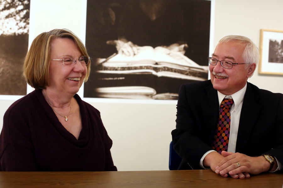 Annette and Dale Schuh smile with art behind them.