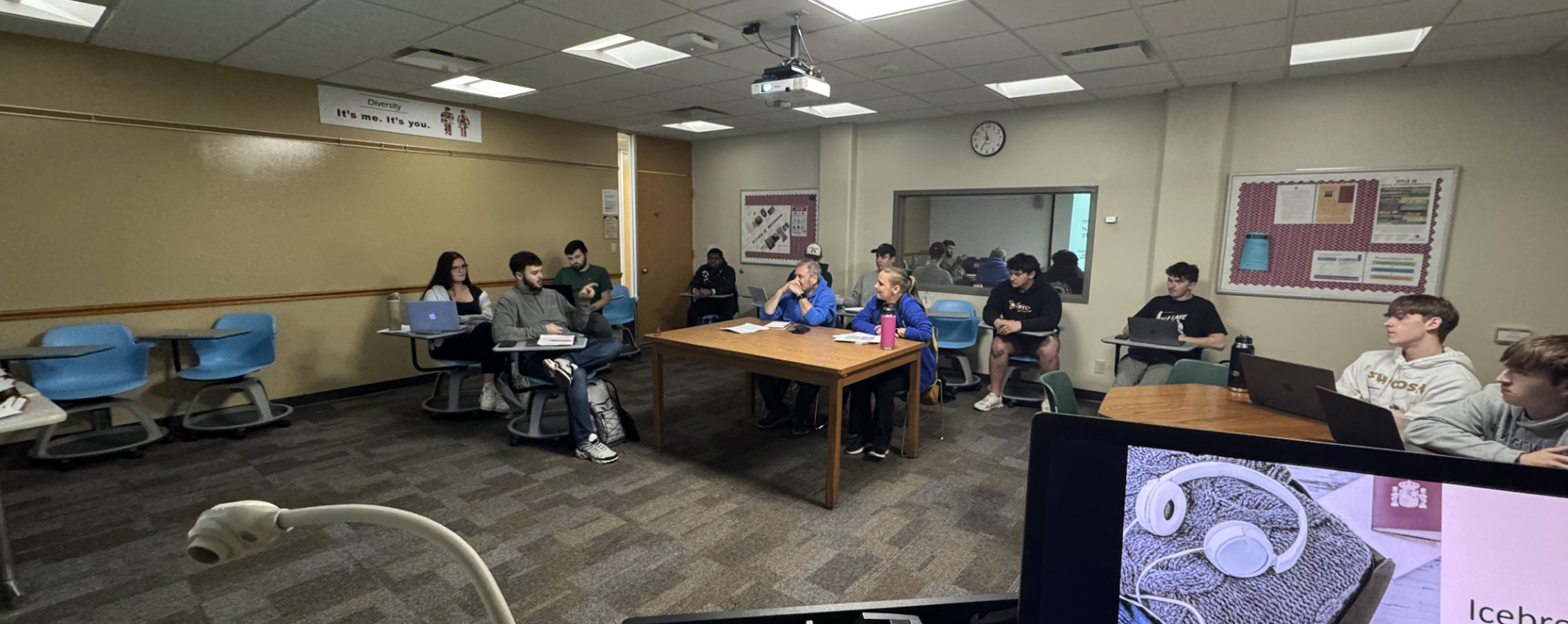 A group of people sit in a circle and have a discussion.