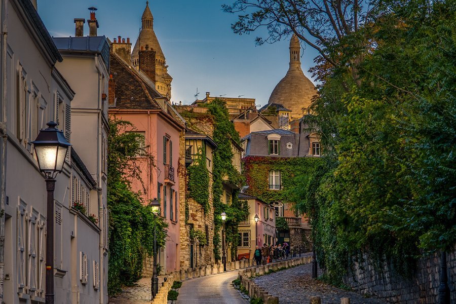 Streets of a European city with vines growing on the buildings.