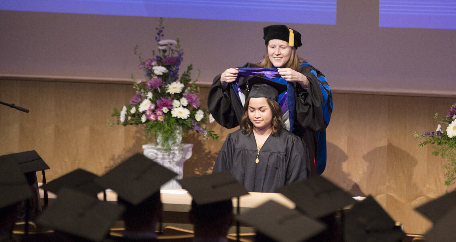 Assistant Professor Abbie Daly hoods a master of professional accountancy graduate at the 2017 Graduate Hooding Ceremony in Hyland Hall.