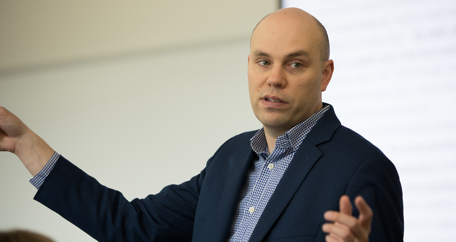 Andy Dahl, assistant professor of marketing, talks with students during one of his classes in Hyland Hall