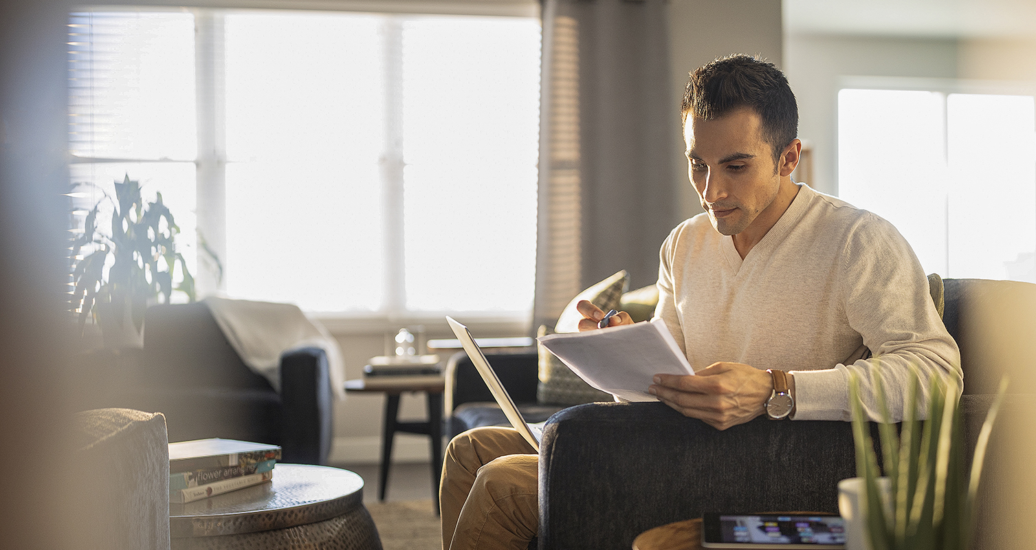 Man studying at home with laptop and tablet