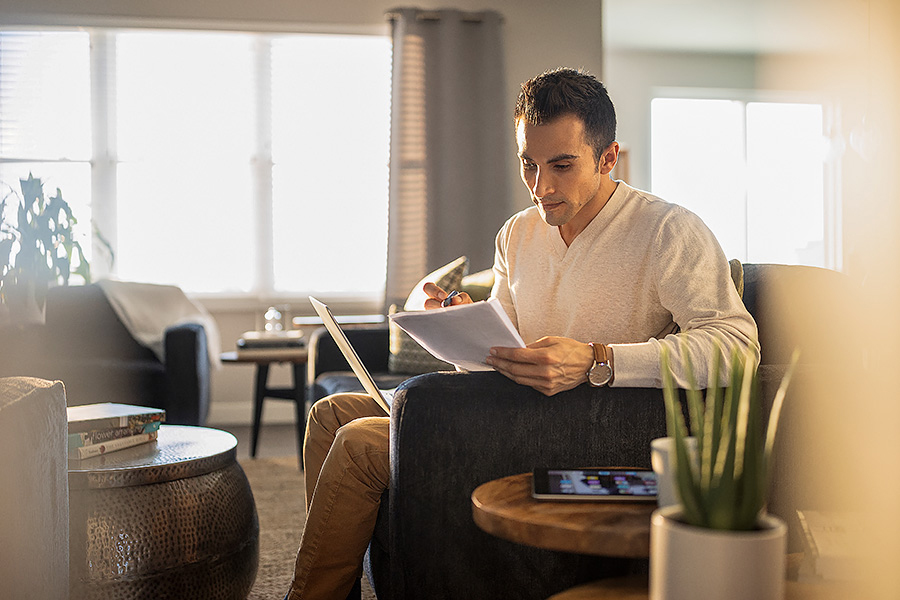 Man studying at home with laptop and tablet