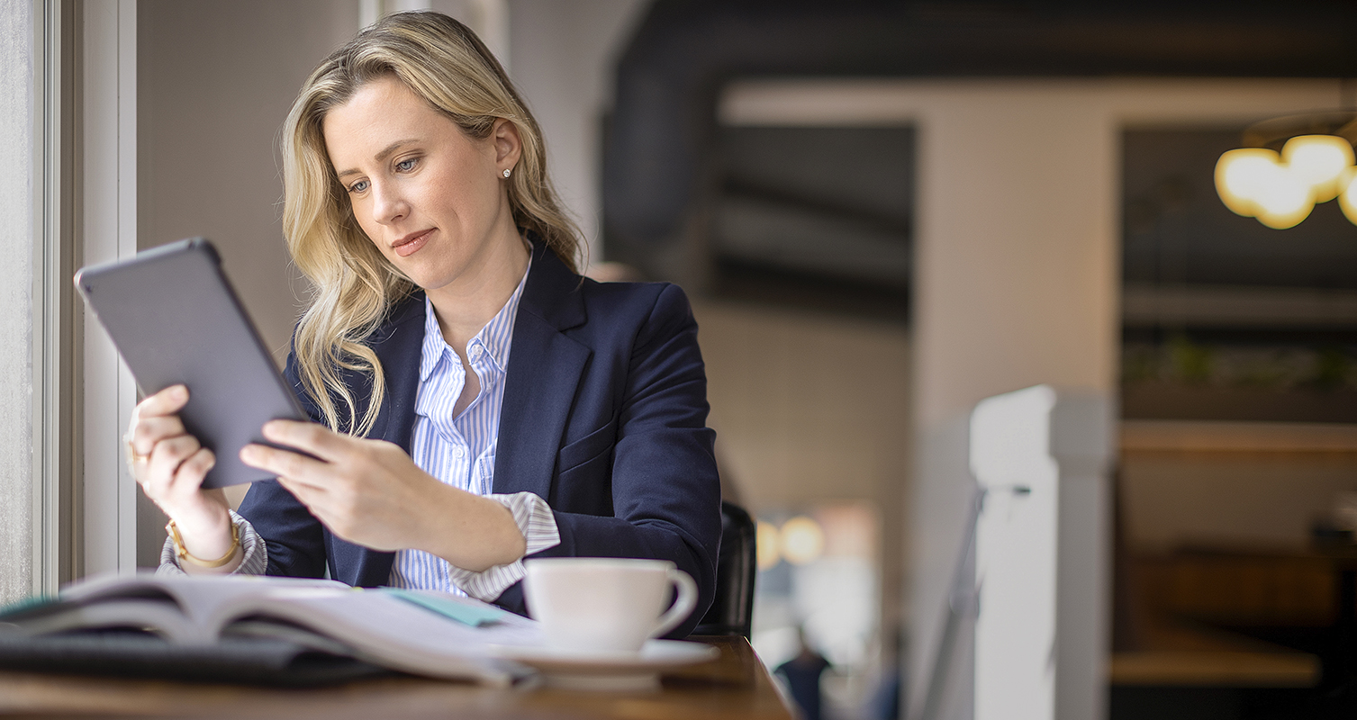 Woman studying with a tablet by cafe window