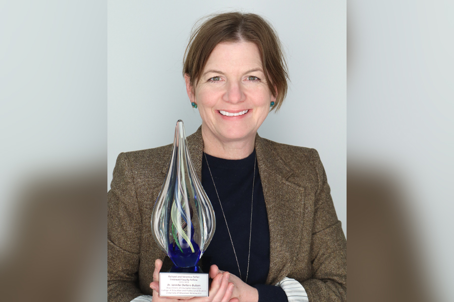 Jennifer Betters-Bubon holding a clear award in the shape of a teardrop.