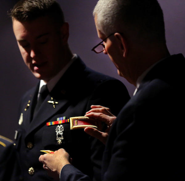 Student in uniform receiving a badge