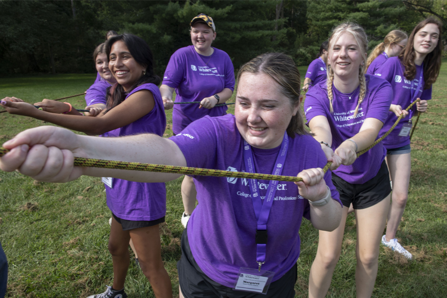 Future teachers wear purple shirts as they do tug of war as a leadership exercse.