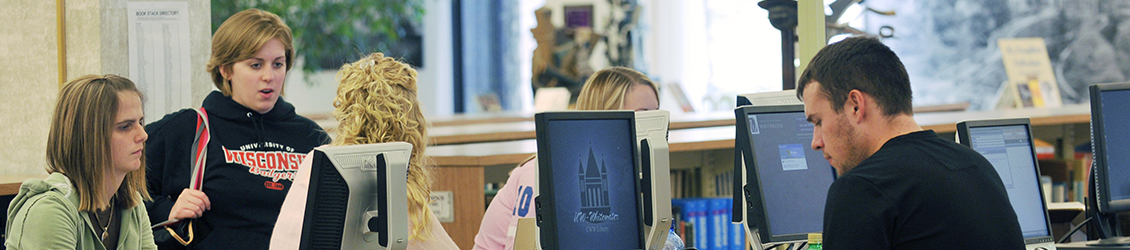 Dean of Students with students studying at the library